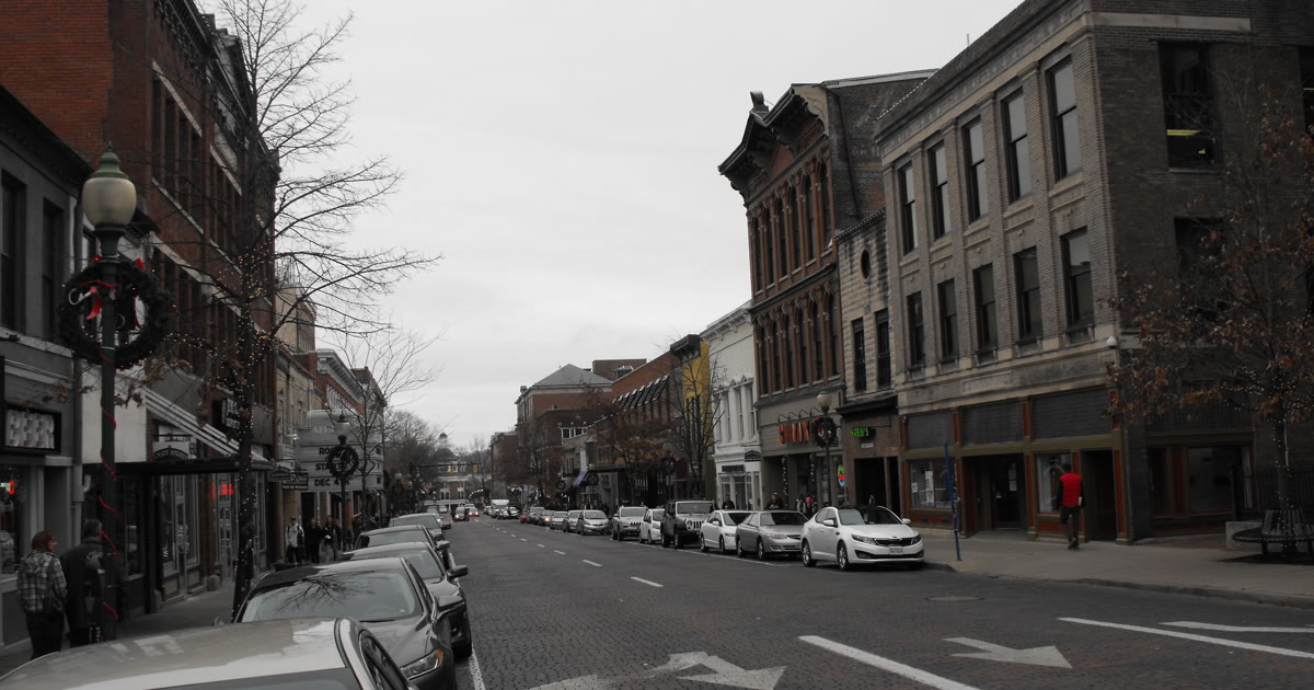 Brick-paved Court Street in downtown Athens, Ohio, lined with historic storefronts and parked cars