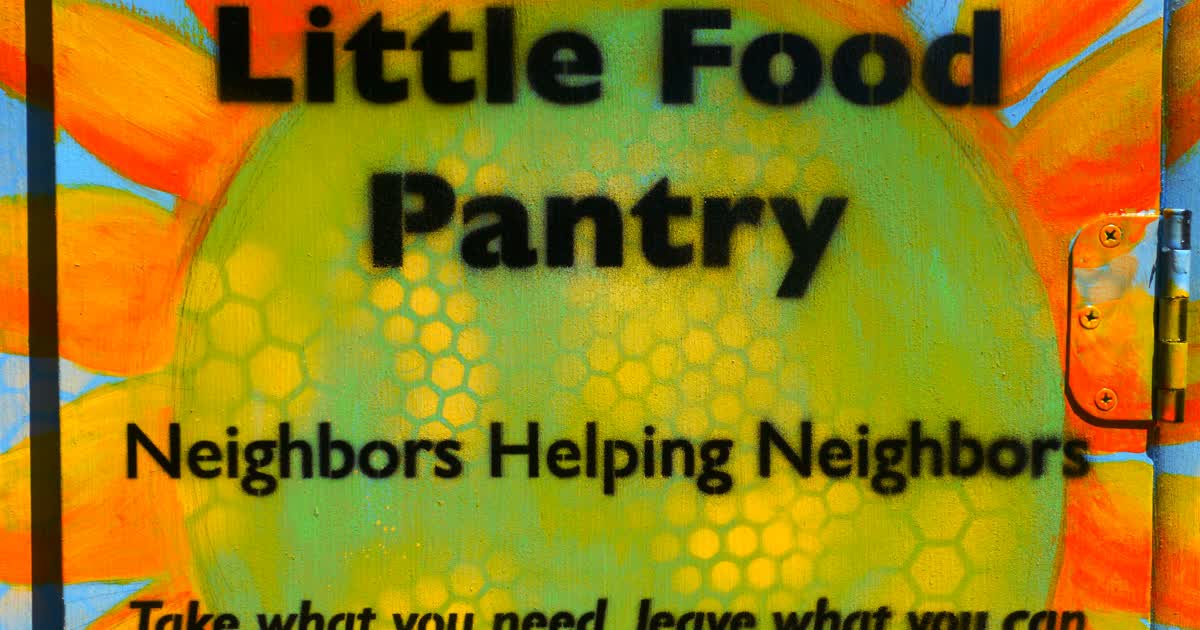 Little Food Pantry cabinet door reading Neighbors Helping Neighbors