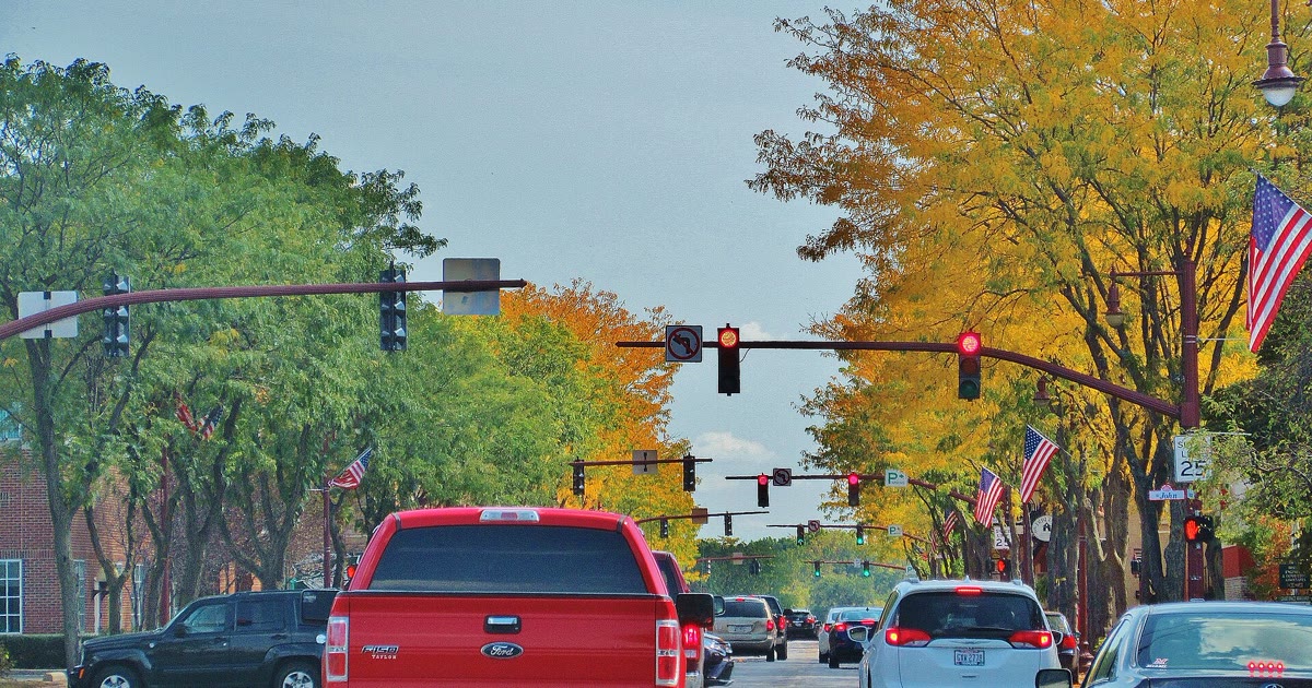 Downtown Maumee Ohio street with traffic lights and American flags in autumn