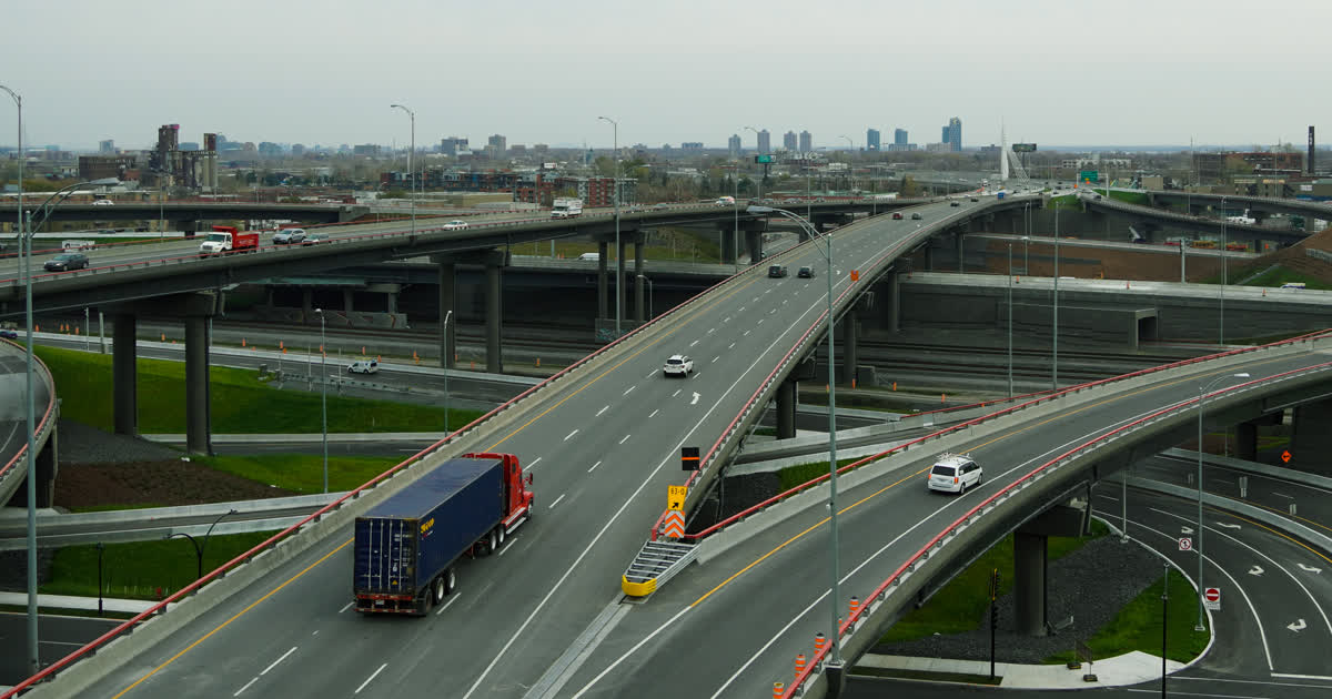Semi truck hauling freight on a highway interchange