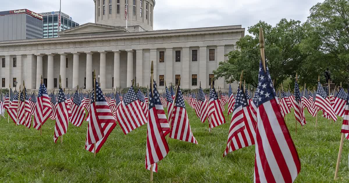 The Ohio Statehouse in Columbus with flags on the lawn