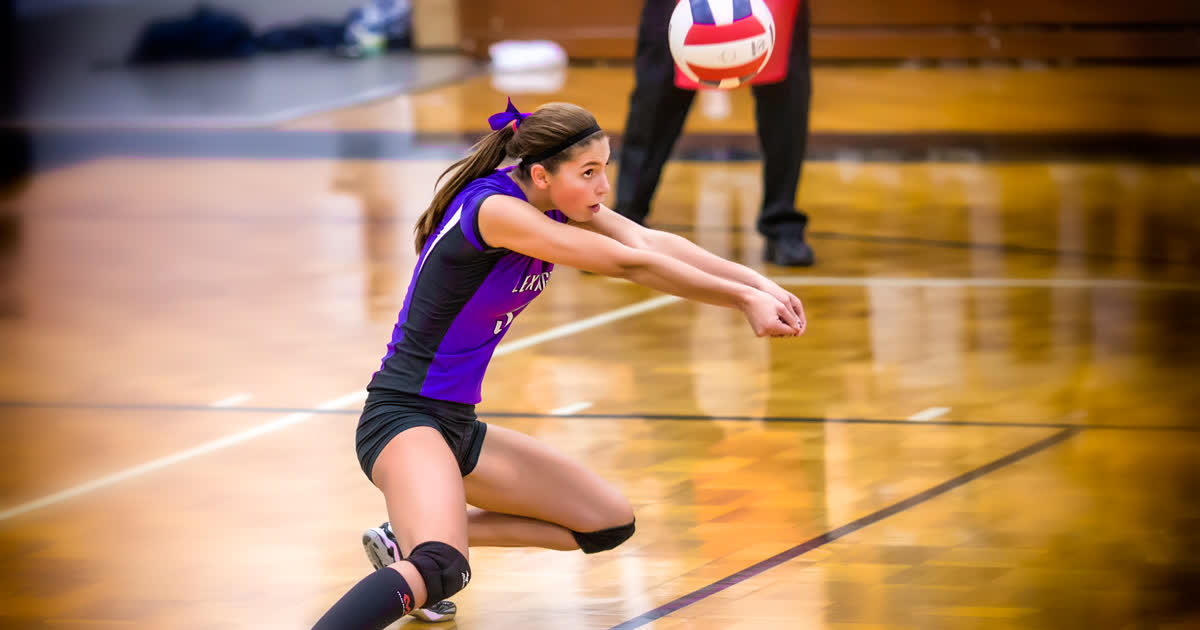 Pleasant volleyball player bumping the ball during a high school match