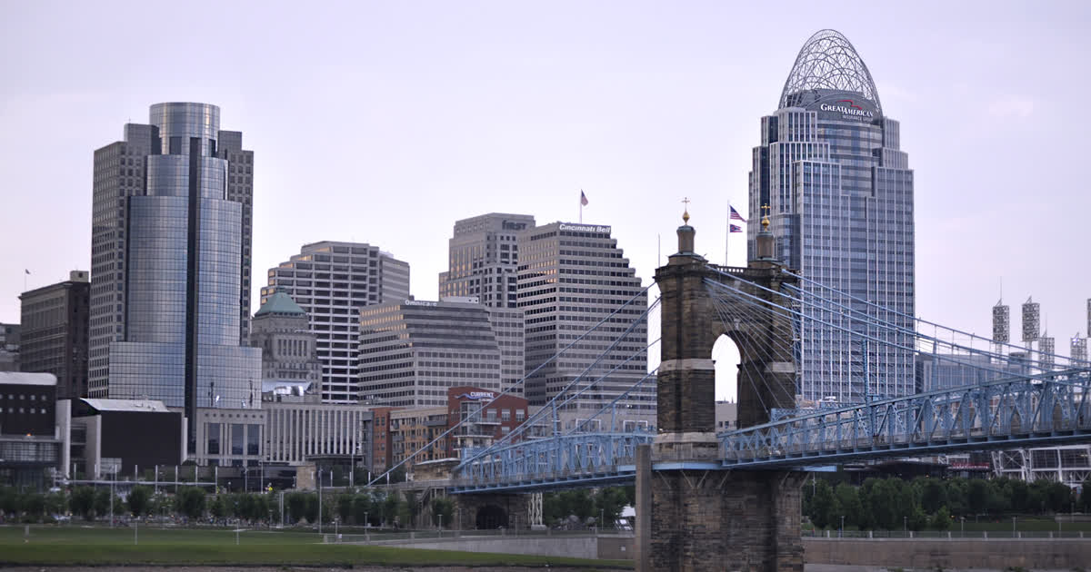 Downtown Cincinnati skyline at dusk with the Roebling Suspension Bridge