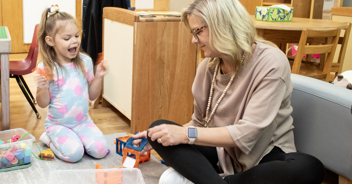 A teacher and a Head Start student play with building tiles together at the Stricker Family Development Center in Fremont