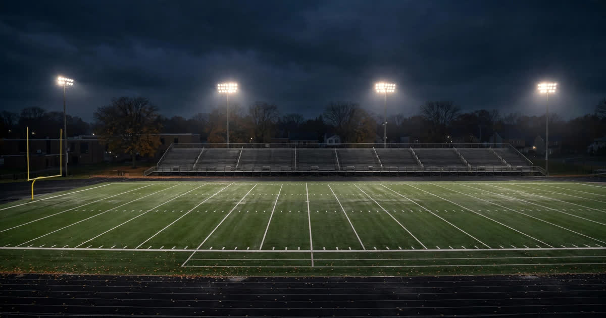 An empty high school football stadium at night under floodlights in Ohio