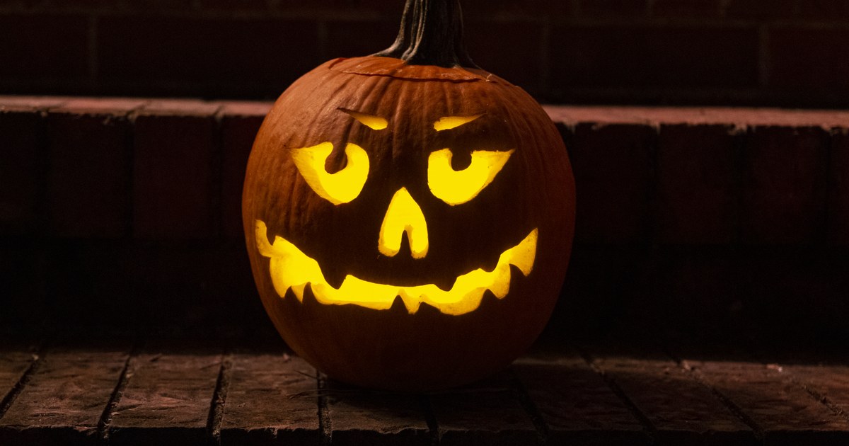 A glowing jack-o-lantern on a porch at night in Ohio fall weather